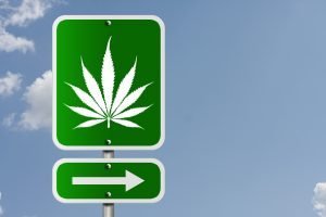 A sign with a marijuana leaf and an arrow