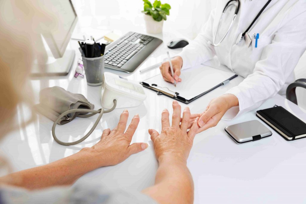 doctor checking patients hands with athritis