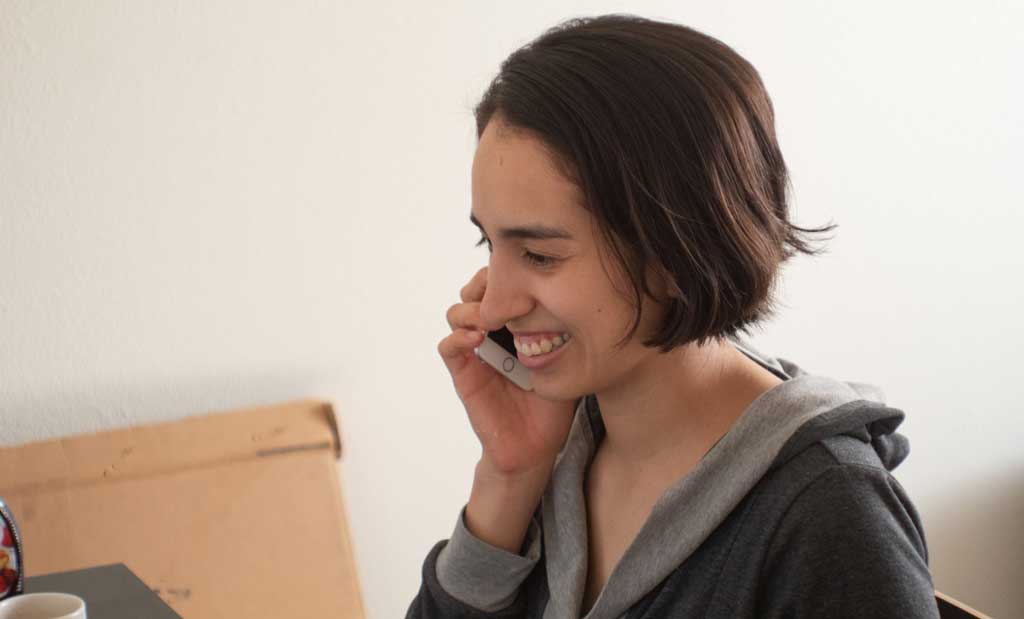 A happy woman speaking to a doctor on a phone.