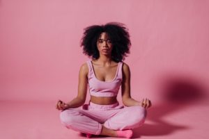Woman Meditating In Pink Room