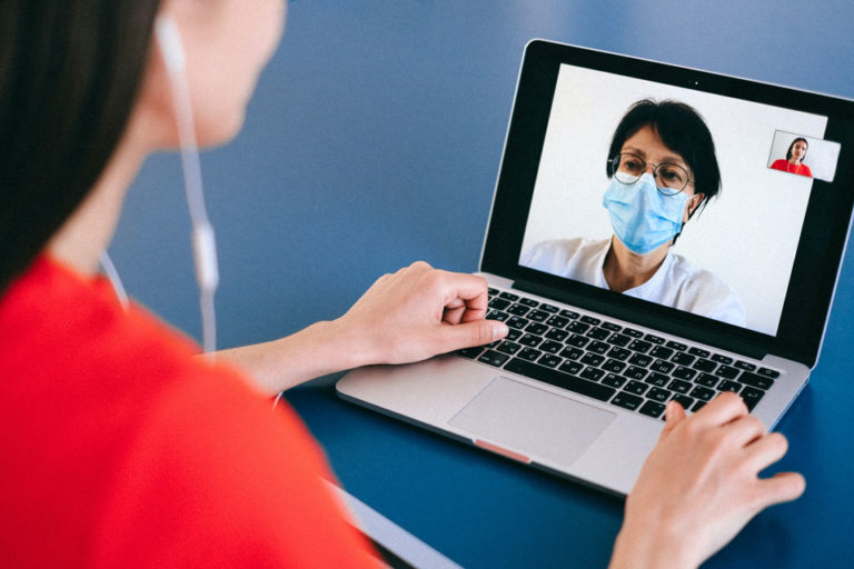 A doctor on a laptop performing a telemedicine visit.