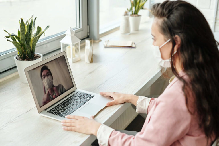 A woman on a laptop during a telemedicine visit