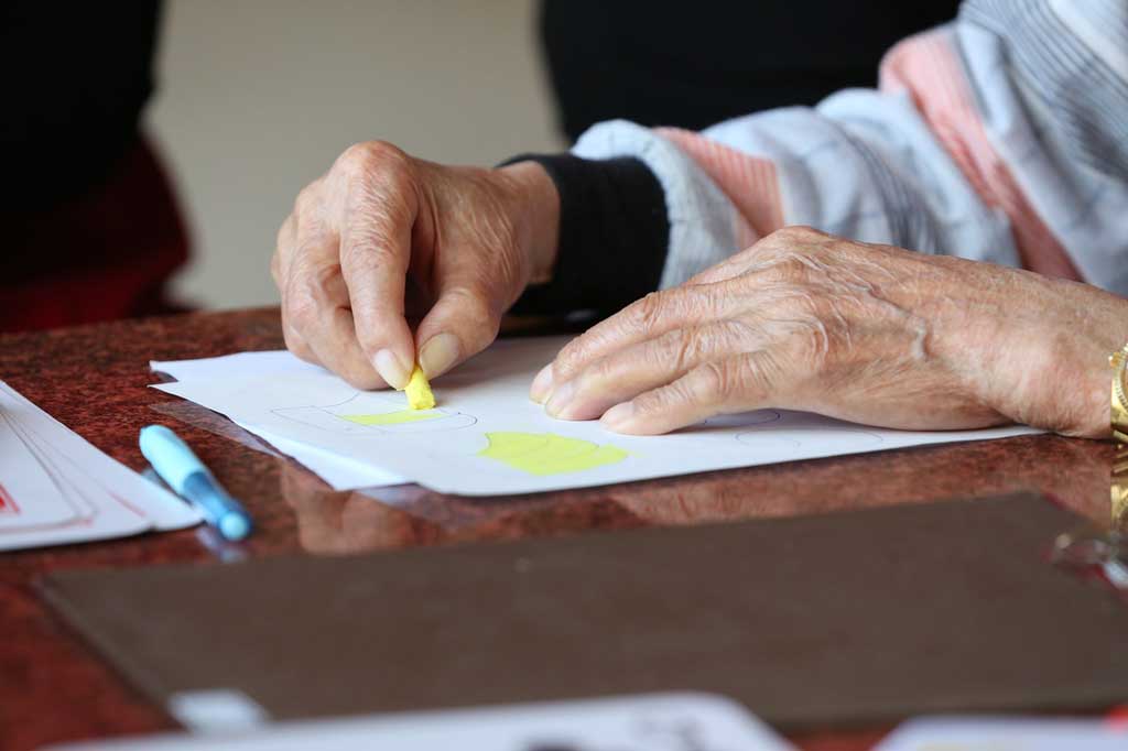 Elderly person’s hands drawing