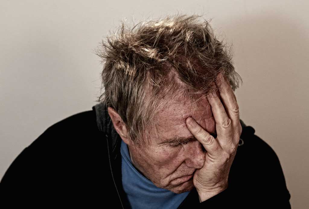 Man with his face in the palm of his hand