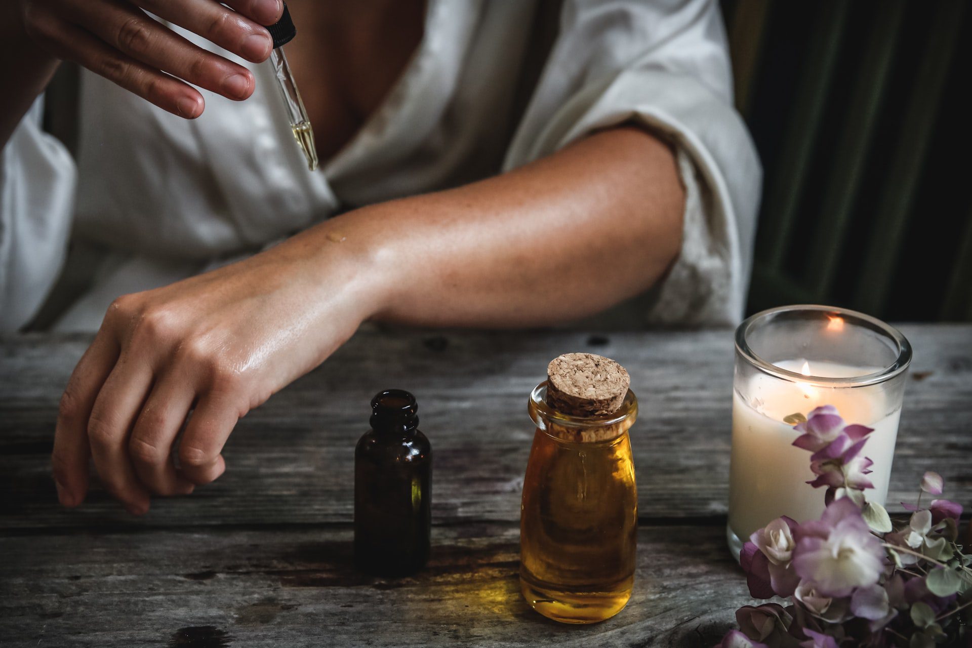 woman dropping essential oil on her hand to reduce inflammation