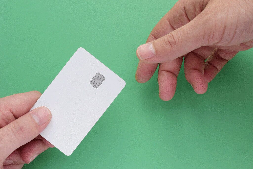A person holding a card in their hand and passing it to another person