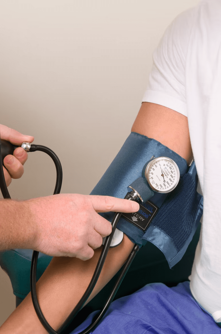 physician checking blood pressure of a patient