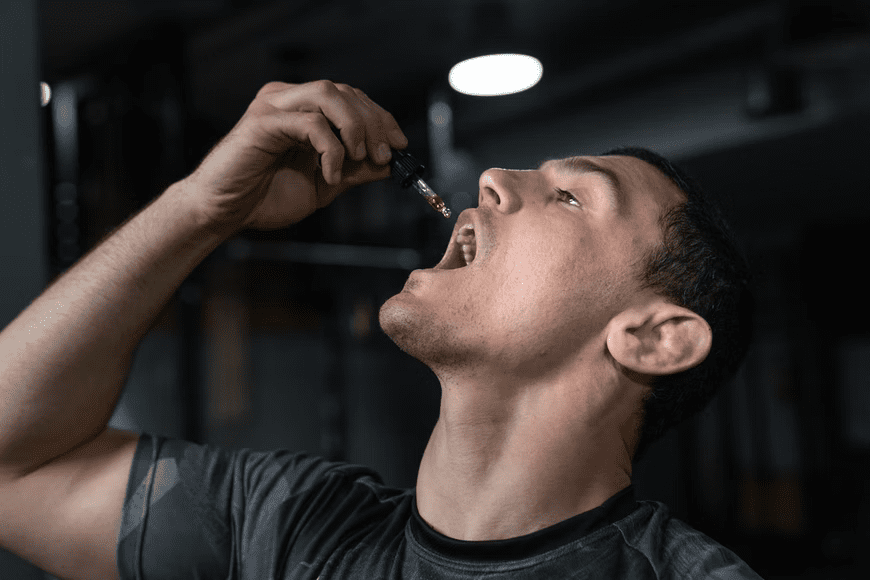 Man putting tincture liquid into his mouth using a dropper
