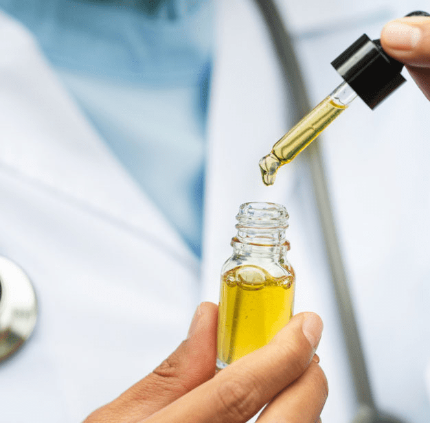 Physician holding dropper of marijuana product
