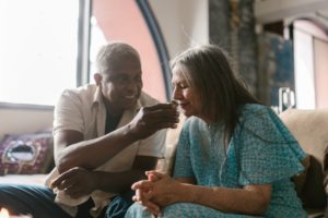 An elderly couple smiling and smelling weed