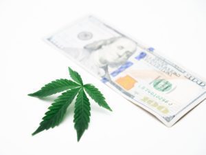 One hundred dollar bill and a cannabis leaf