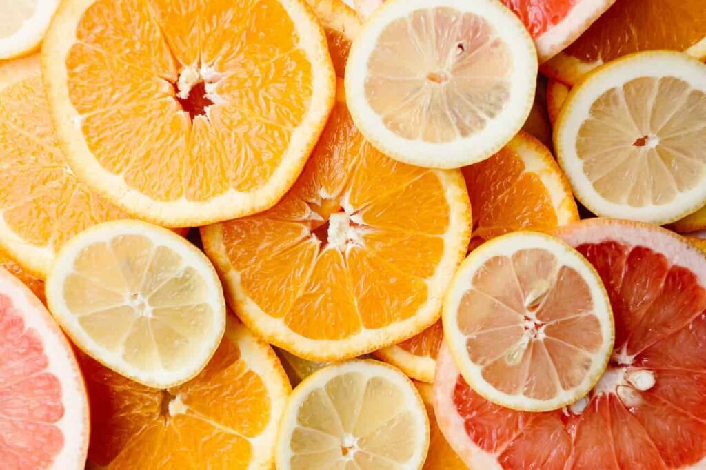 A vibrant, top-down arrangement of citrus slices, including oranges, lemons, and grapefruits, illustrating the natural sources and zesty aromatic profile of the Limonene Terpene.