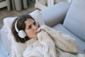 A woman lying down and listening to music