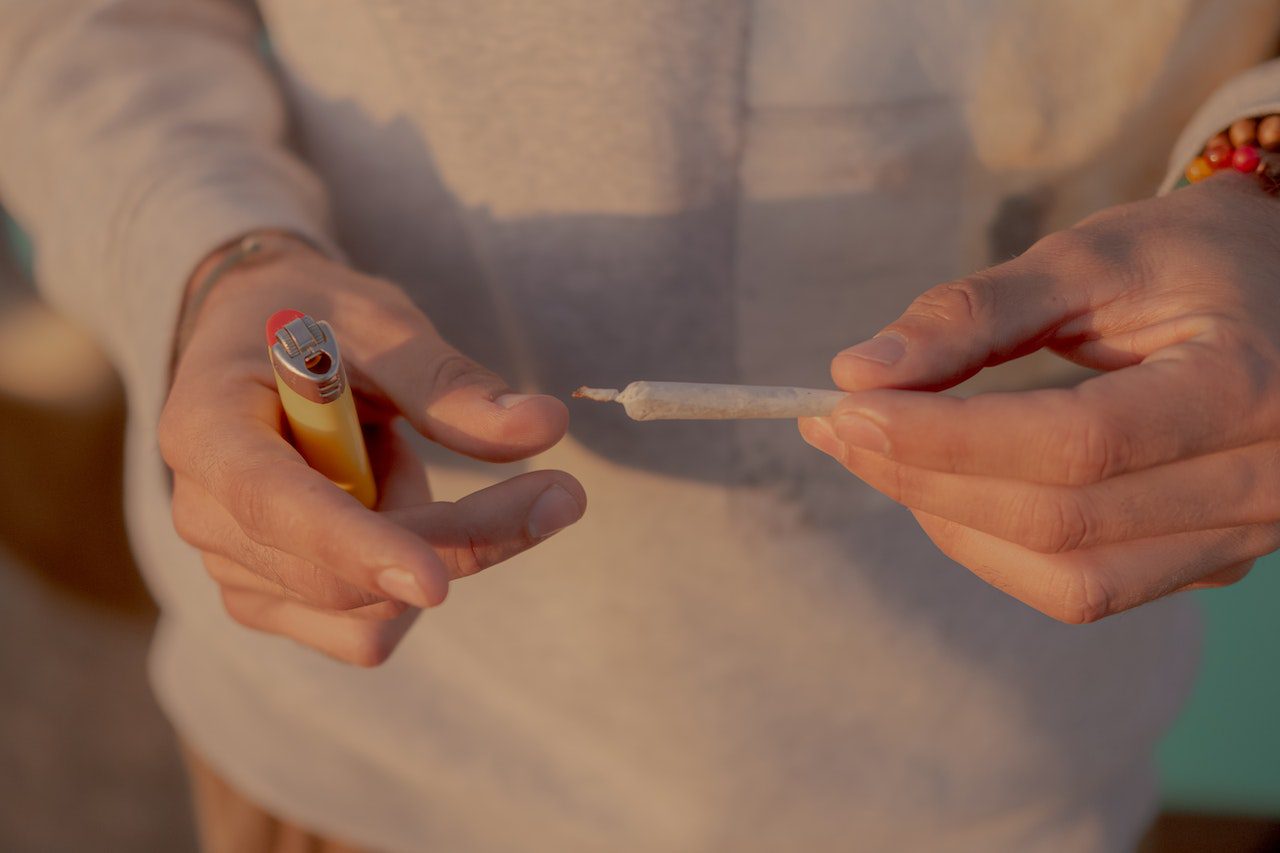 Man holding a lighter and joint in both hands