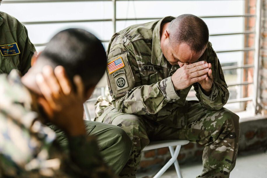 A soldier with PTSD resting his head on his hands