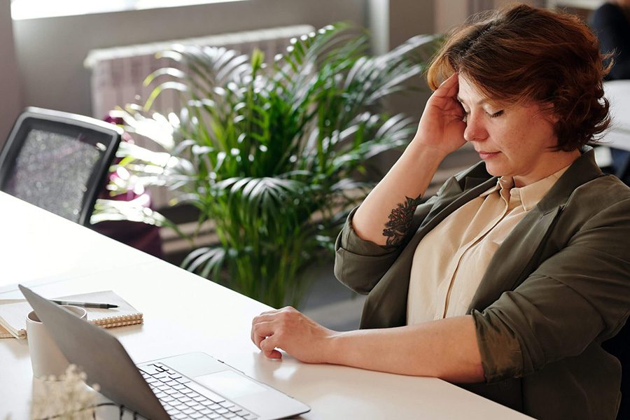 A woman with a migraine touching her head