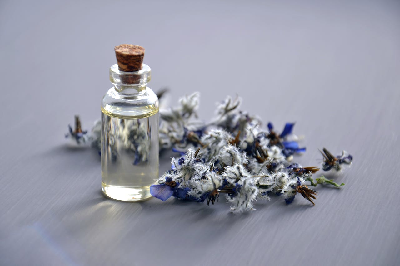 Lavender essential oil next to lavender flowers