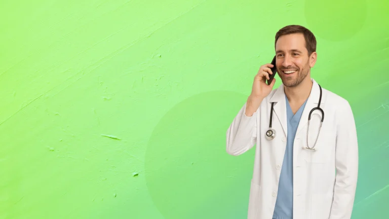 Smiling medical marijuana doctor in Tampa wearing a white coat and stethoscope, talking on the phone.