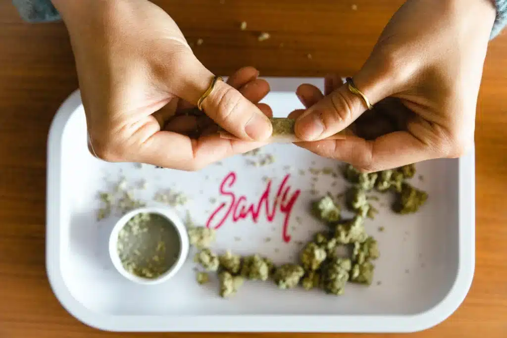 Hands preparing cannabis flower on a rolling tray at a medical marijuana dispensary in Florida.