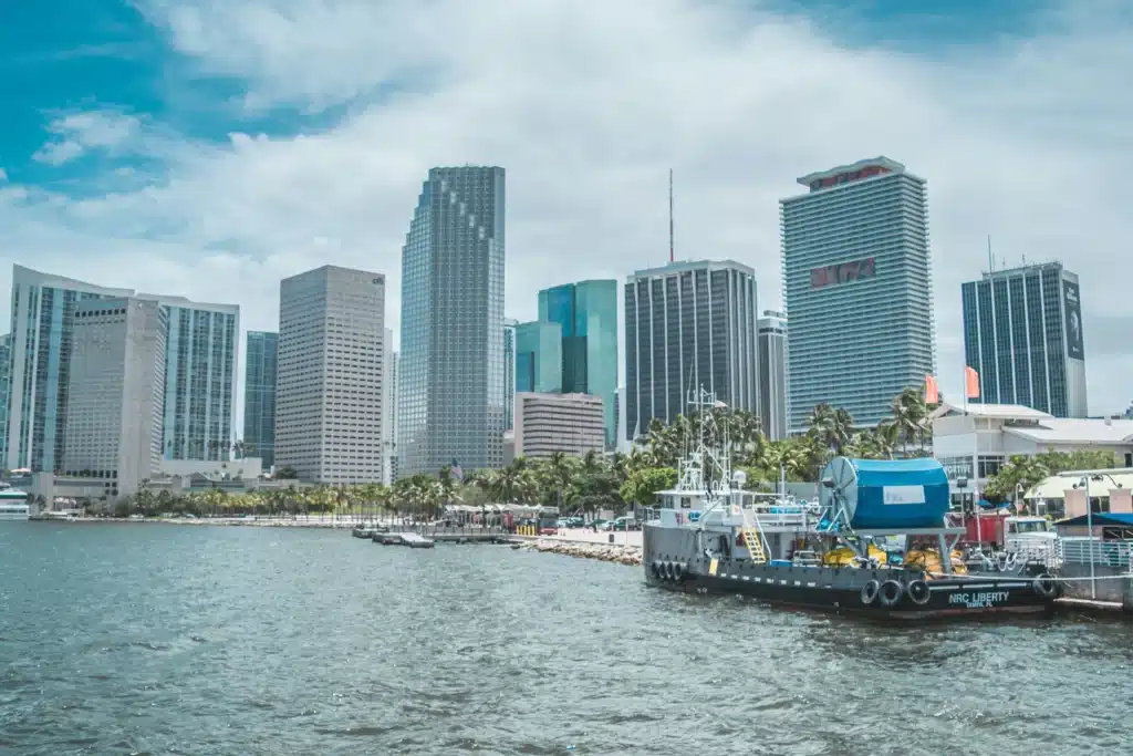 Miami waterfront skyline with high-rise buildings and a docked boat, representing the city location for Medical Marijuana Card renewal in Miami.