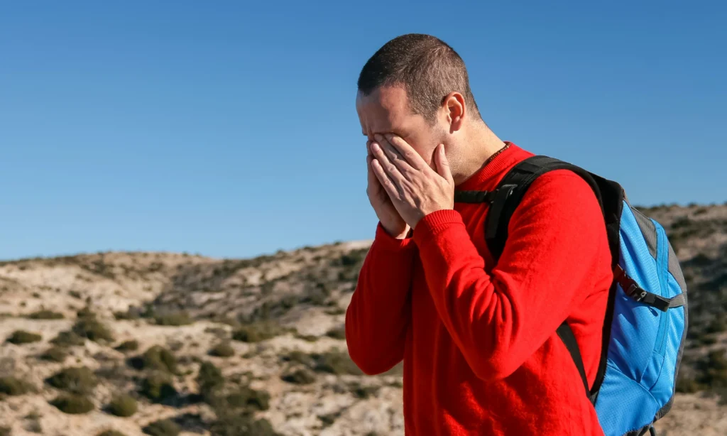 Does Weed Help Nausea? Person experiencing nausea outdoors, highlighting symptoms often managed with medical cannabis.